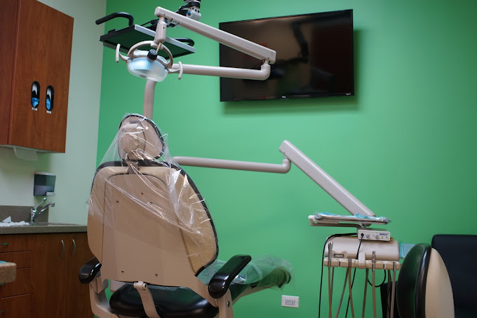 Image showing one dental operatory with a television on a green wall.